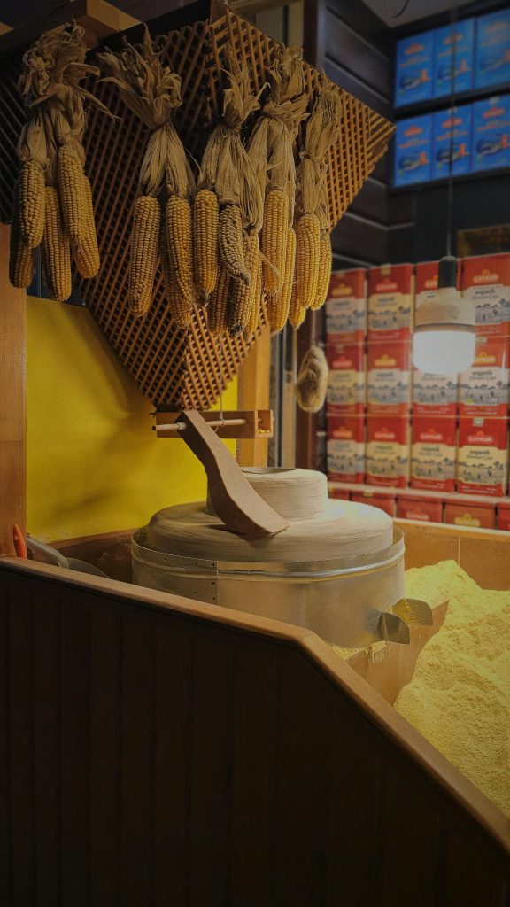 Hanging corn cobs and mill in a traditional Turkish setting, showcasing local culture.